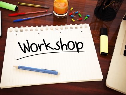Image with pens and open exercise book that says 