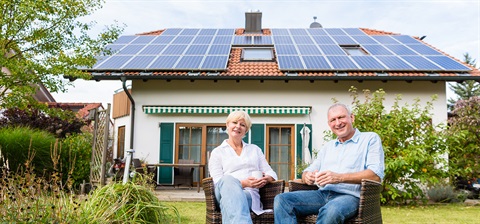 Elderly couple sitting in garden with solar on their roof