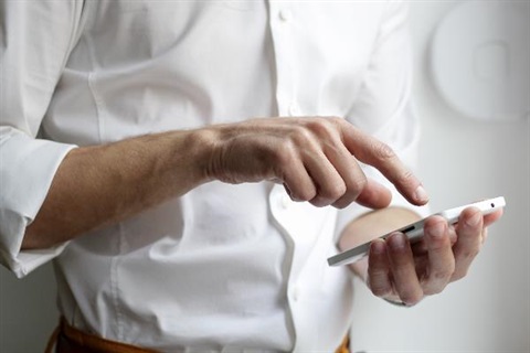 Man holding a phone and typing.