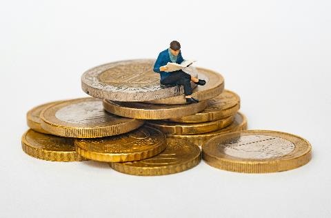 A man sitting on a pile of coins